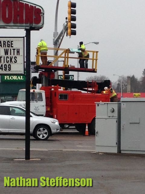 workers putting up sign in wintry mix